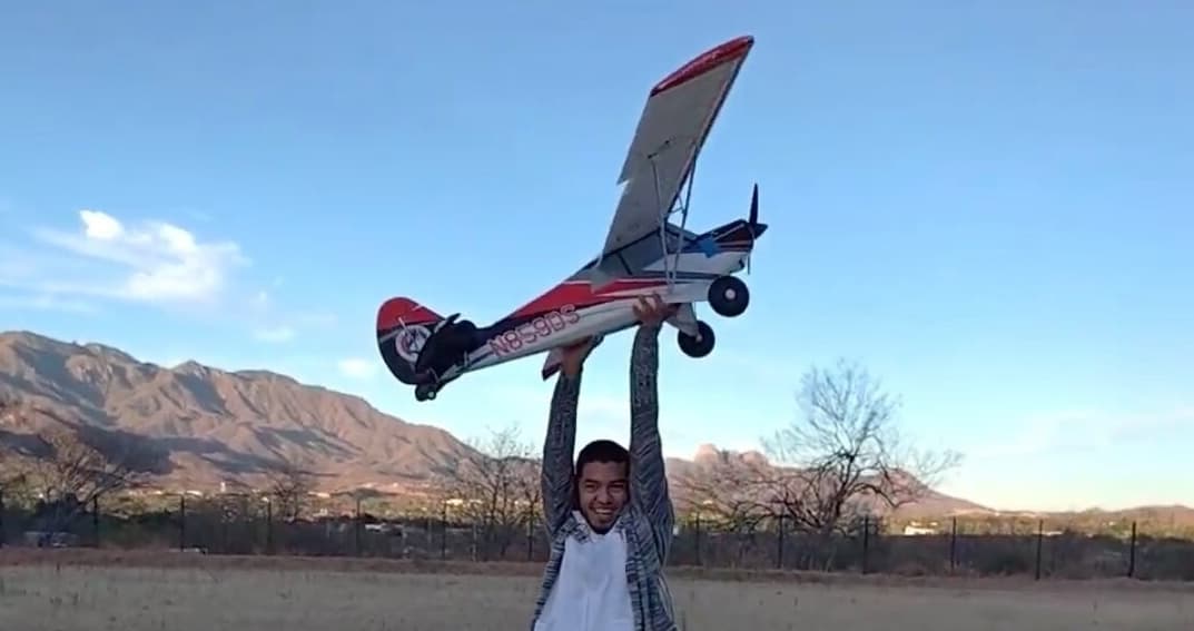 Student proudly holding completed medical delivery drone